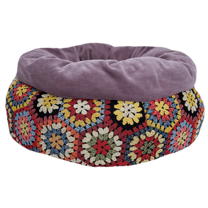 Multicolored floral-patterned pet bed with a purple cushion on a transparent background