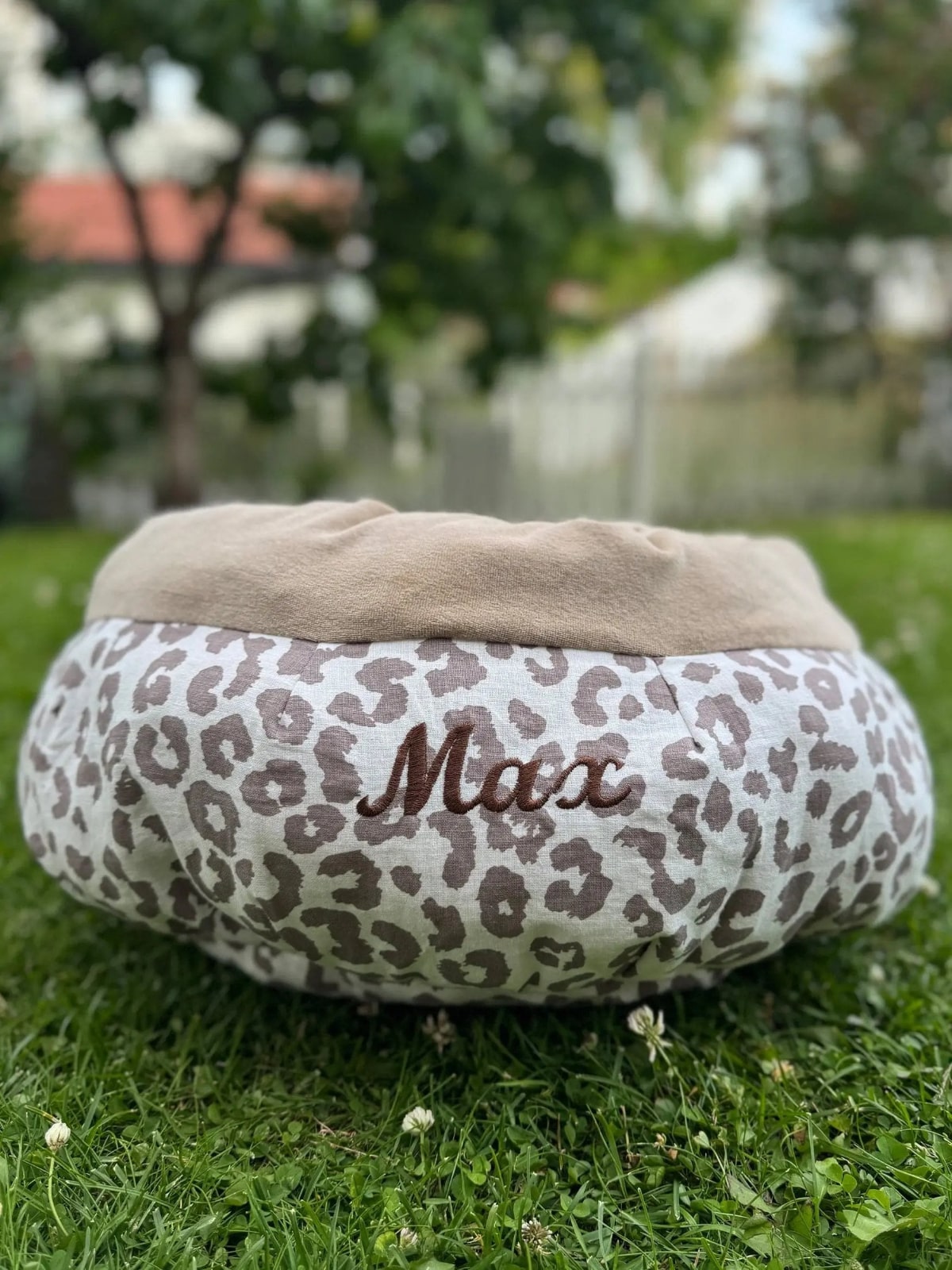 Leopard print pet bed with 'Max' on a grassy area